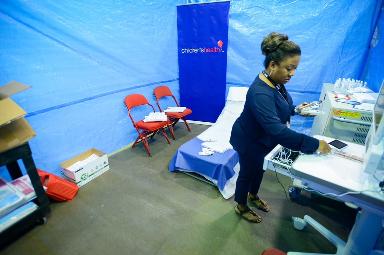 Media(D170829R): Tamara Perry (Director TeleHealth Operations, CHST Virtual Health) sets up the Virtual Health clinica area. CHST has placed a Virtual Health clinic and will have CHST doctors onsite in a Pediatric Clinic at the Dallas Convention Center as evacuees and refugess from Hurrican Harvey begin to arrive.