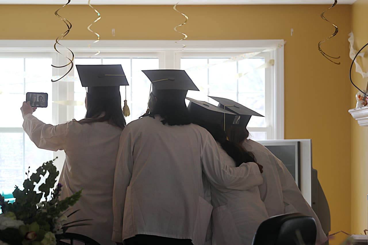 <b>Graduación en casa.</b> Estudiantes de la facultad de medicina de la Universidad de Massachusetts, participan en una videoconferencia de FaceTime en Worcester, Massachusetts. 31 de marzo. Esta graduación había sido pospuesta por la pandemia, y finalmente se realizó vía Zoom.