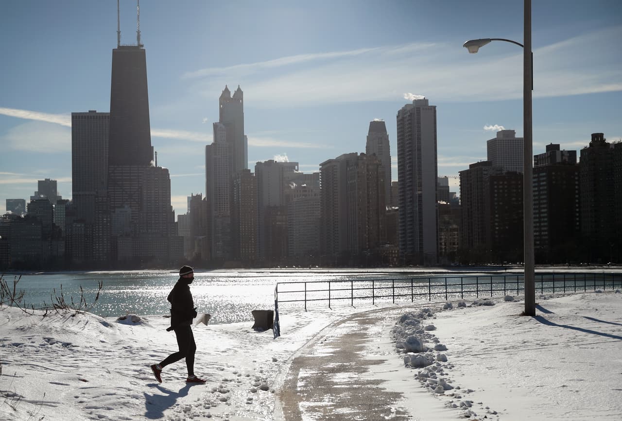En Chicago, un hombre corre junto a la orilla del lago a pesar de temperaturas de un solo dígito que está sufriendo la ciudad y los vientos a menos 0.