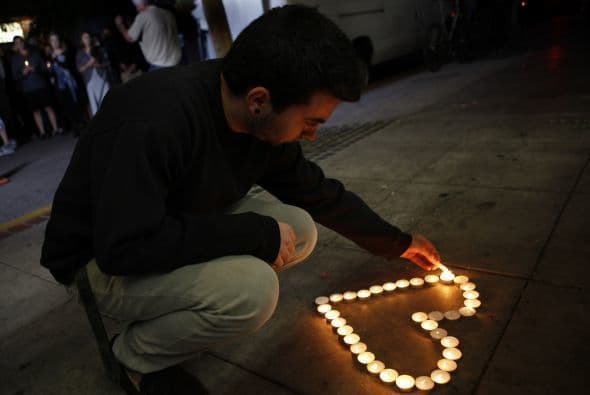 Un estudiante de la UC en Santa Barbara enciende velas en un monumento dedicado a las víctimas de la masacre cometida por Elliot Rodger.