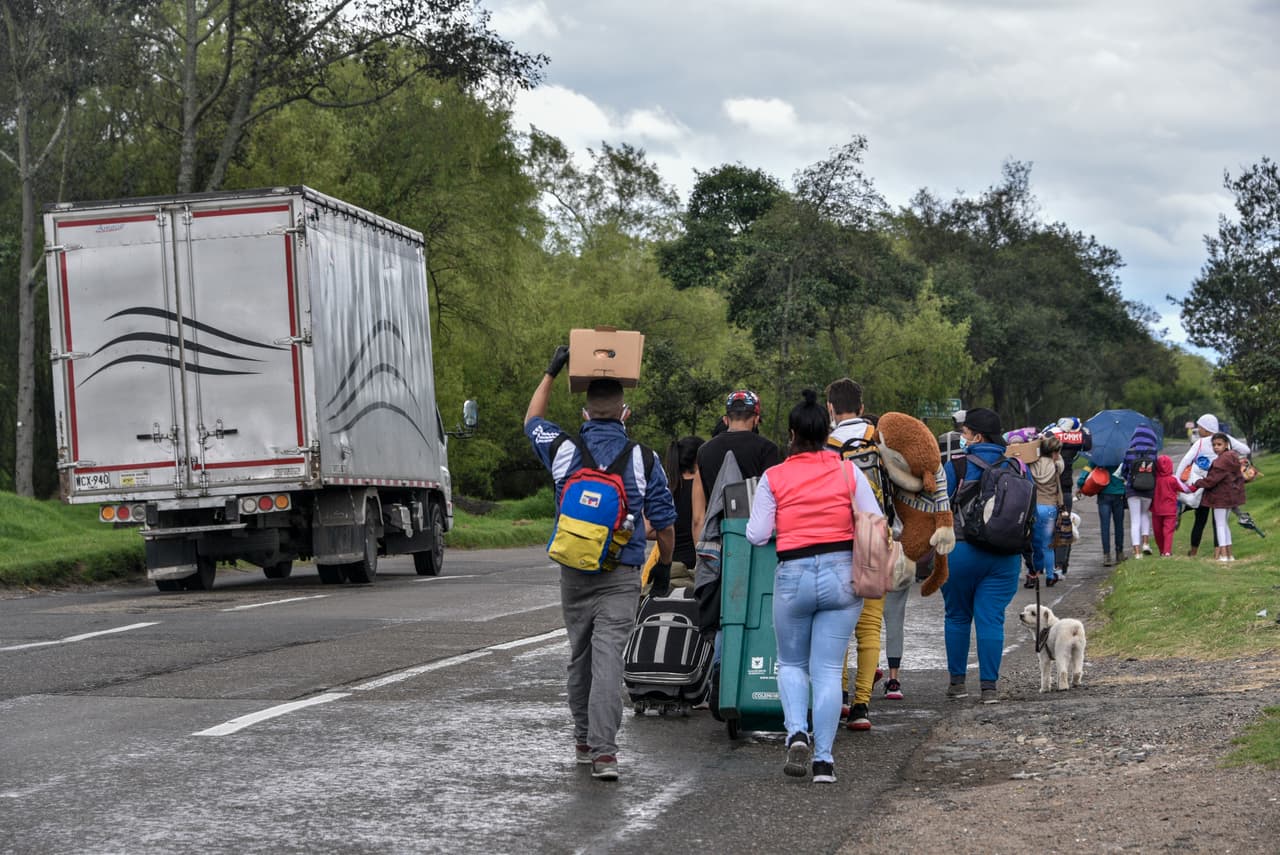 Migrantes venezolanos de regreso a su país caminan con sus pertenencia a las afueras de Bogotá, la capital de Colombia, el 6 de abril. Los viajantes se reúnen en caravanas ambulantes y se dirigen al cruce fronterizo en Cúcuta a pie, un trayecto 340 millas que puede tomar hasta 15 días. Otros han llegado a la frontera en autobues desde varias partes del país.