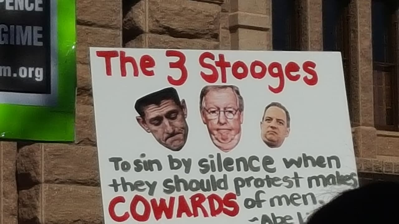 Mensaje: “Las tres marionetas. El pecado por el silencio cuando deben protestar hace cobardes a los hombres”, citando a la poeta estadounidense Ella Wheeler Wilcox. En el cartel se ven fotos de Paul Ryan (presidente de la Cámara de Representantes de Estados Unidos), Mitch McConnell (líder de la mayoría republicana en el Senado de Estados Unidos) y Reince Priebus (el jefe de gabinete de la Casa Blanca). 
<br>