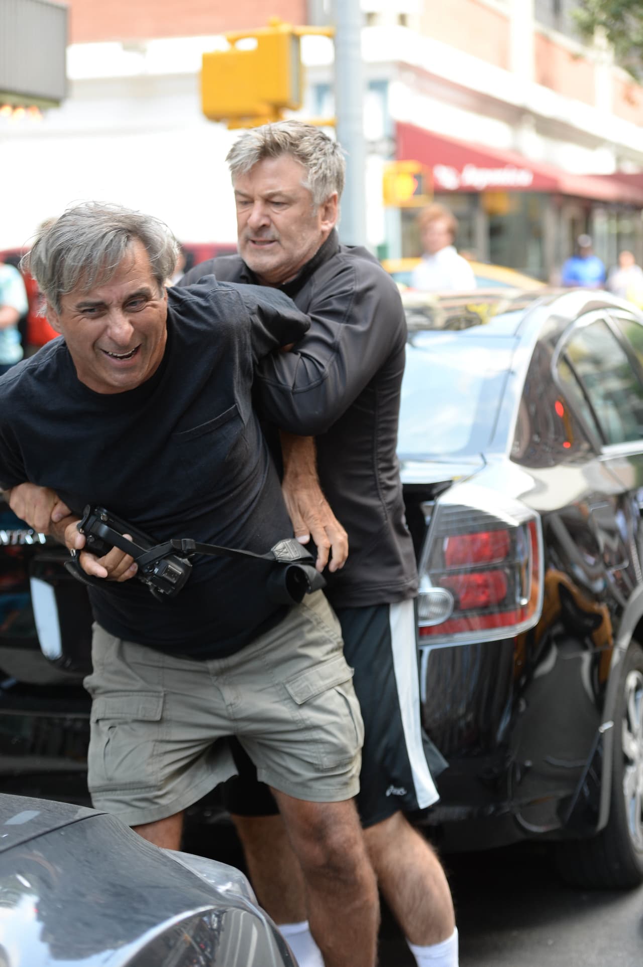 Le dobló el brazo y lo empujó contra su coche.