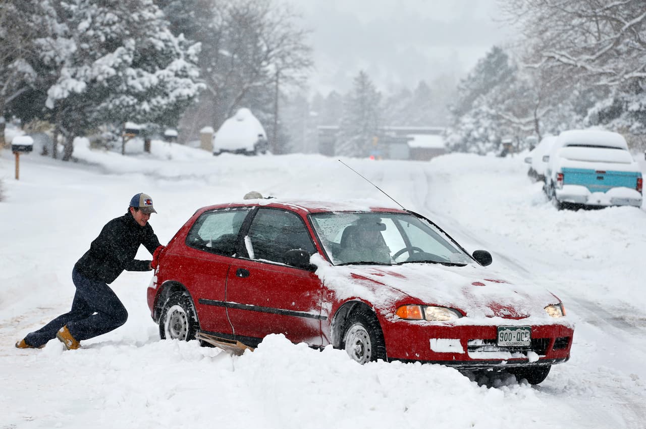 Alex Vlasity ayuda a empujar un coche que se atascó a consecuencias de las nevadas en Boulder, donde se registró la mayor tormenta de la temporada en lo que va del año.