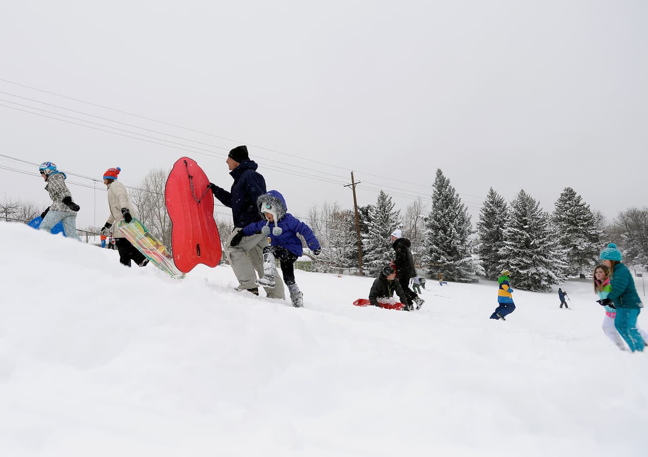 Algunas familias de Boulder aprovechan la nieve que ha quedado en las colinas para divertirse.