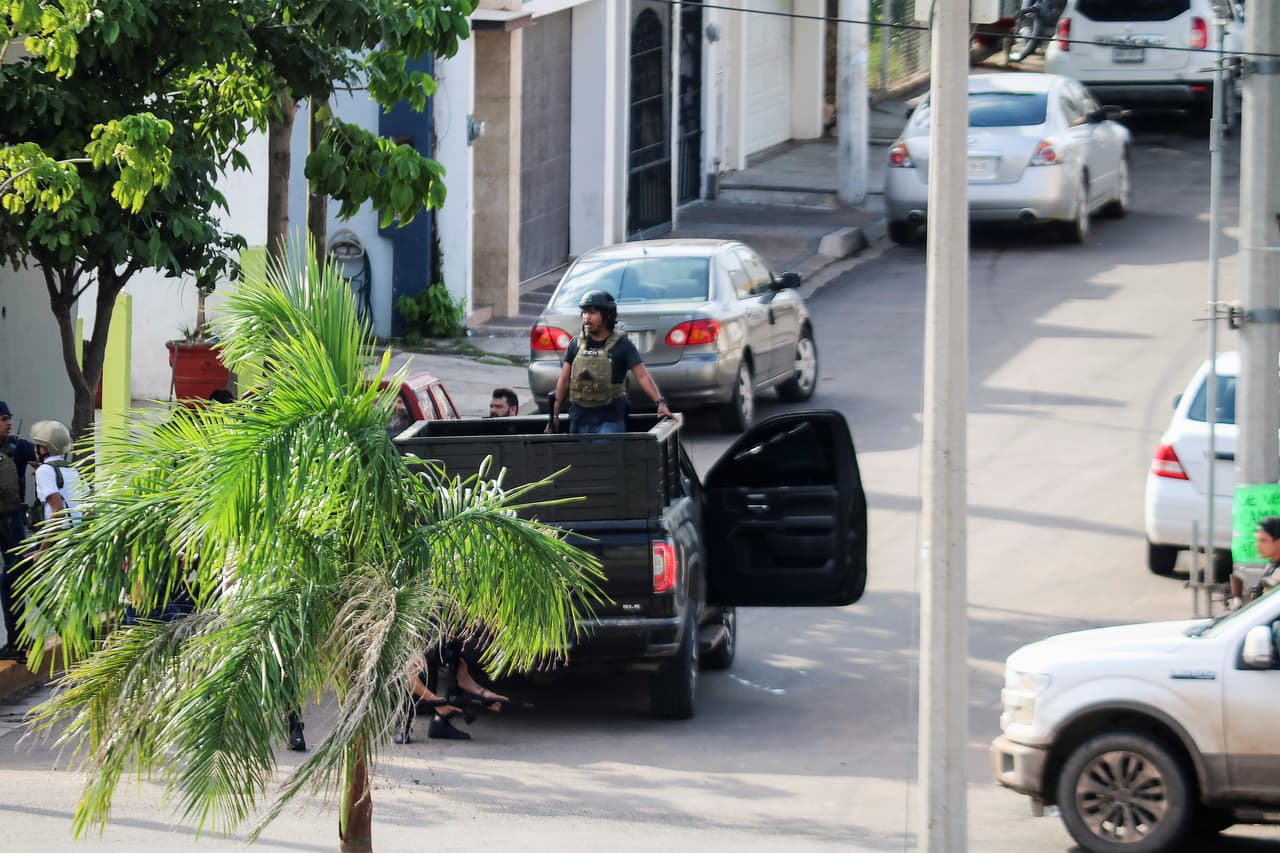 Uno de los hombres del cártel de Sinaloa, armado y con chaleco antibalas, se desplaza por la ciudad en medio del enfrentamiento con autoridades federales.
