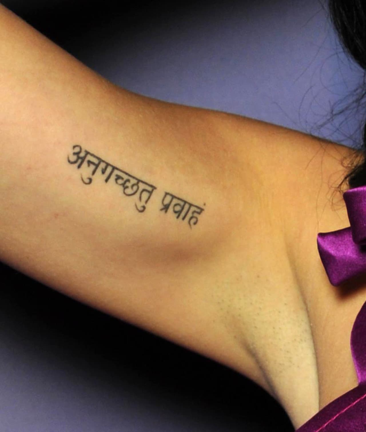 La frase en sánscrito dice "Anuugacchati Pravaha", que en castellano significa "ir con la corriente".