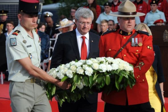El primer ministro de Canadá, Stephen Harper, sostiene una corona de flores durante la ceremonia Franco-canadiense en Juno Beach, en Courseulles-sur-Mer, en Normandía.