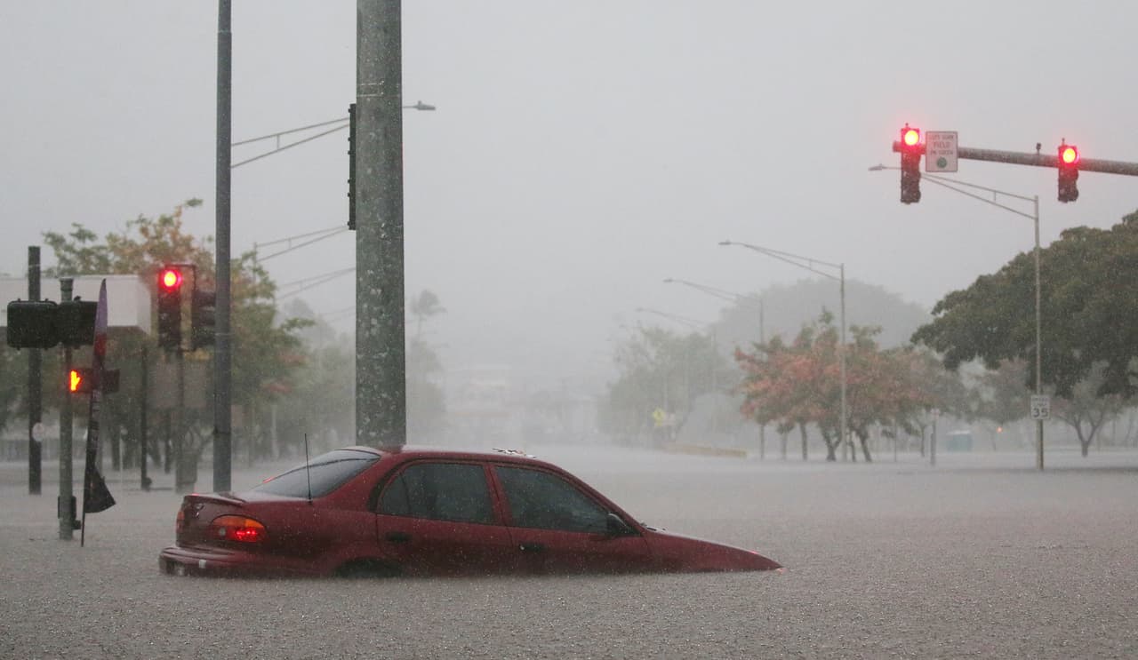 Este carro quedó parcialmente sumergido en una calle de Hilo, en Hawaii, tras las torrenciales lluvias que trae el huracán Lane.