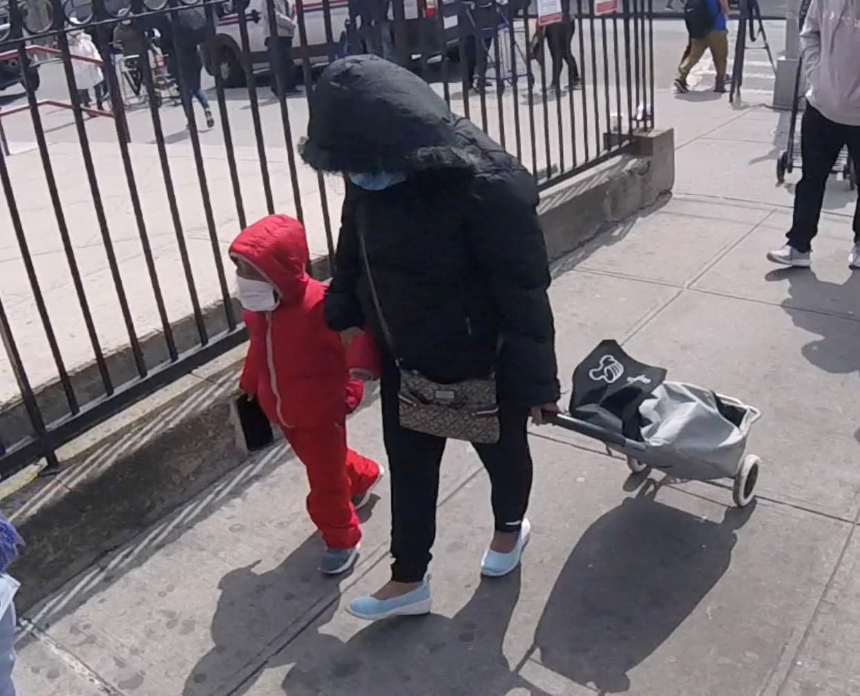 Madre e hija caminan agarradas de la mano mientras esperan en una fila afuera de una iglesia que repartía comida en Corona, Queens, a principios de la pandemia. 17 de abril, 2020.