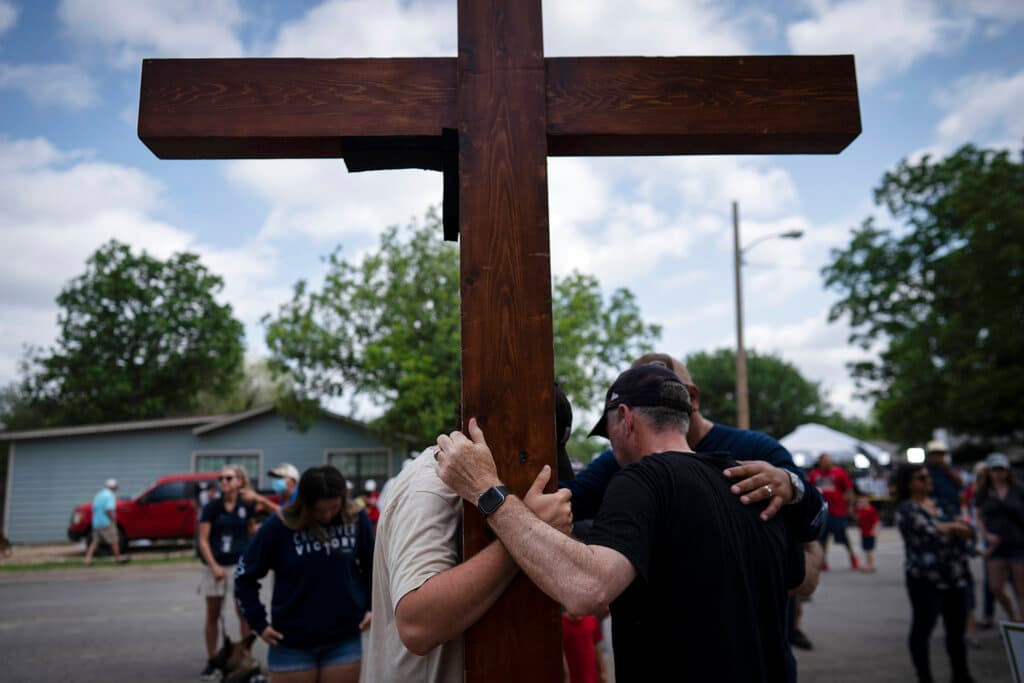 Dan Beazley, a la derecha, con su hijo Joey Beazley, de Detroit, llevan una cruz de madera mientras rezan fuera de la Escuela Primaria Robb en Uvalde. Durante las próximas dos semanas y media, los habitantes de este pueblo de Texas se despedirán de los niños y de las docentes en un funeral y un entierro tras otro. Más información: 
<a href="https://www.univision.com/noticias/estados-unidos/tiroteo-escuela-primaria-uvalde-reclamos-de-cambio-leyes-armas">"Los llevamos a la escuela para estudiar, no para que los maten", reclaman en Uvalde.</a>