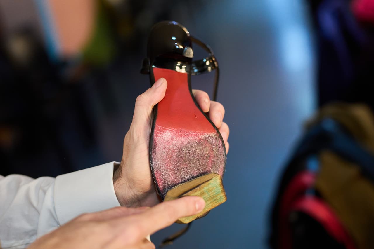El bailarín Nicolas Shell le arregla uno de los zapatos a su compañero Nair Schinca antes de su actuación en el Campeonato Mundial de Tango en Buenos Aires.
