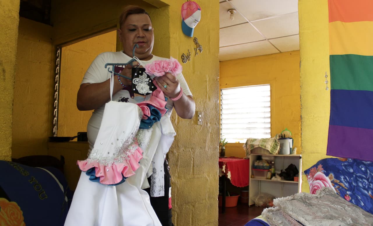 Venus Nolasco, una mujer trans que dirige el colectivo LGBTQ de San Miguel "Perlas de Oriente", sostiene el disfraz que usaría en un desfile su amiga Zashy Zuley del Cid Velásquez en el Día Internacional Contra la Homofobia, en San Miguel, El Salvador, el martes 25 de mayo de 2021.
