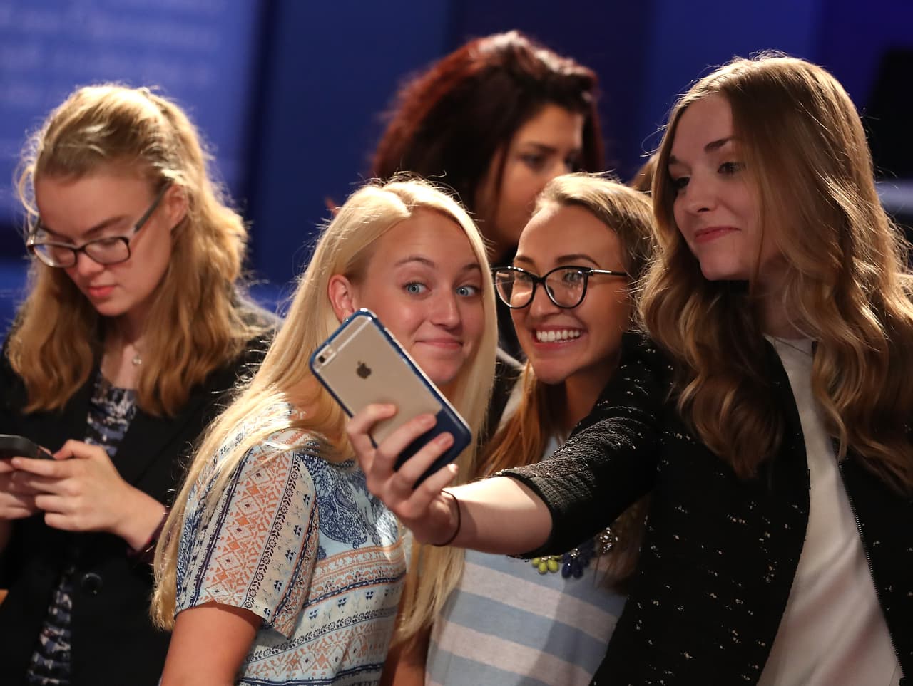 Asistentes se toman fotos antes de tomar asiento.