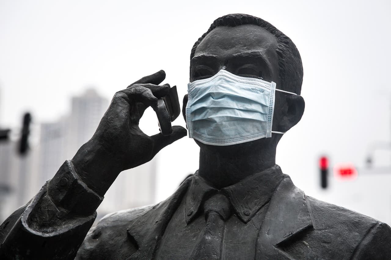 Un tapabocas en una estatua en una calle de Wuhan, China.