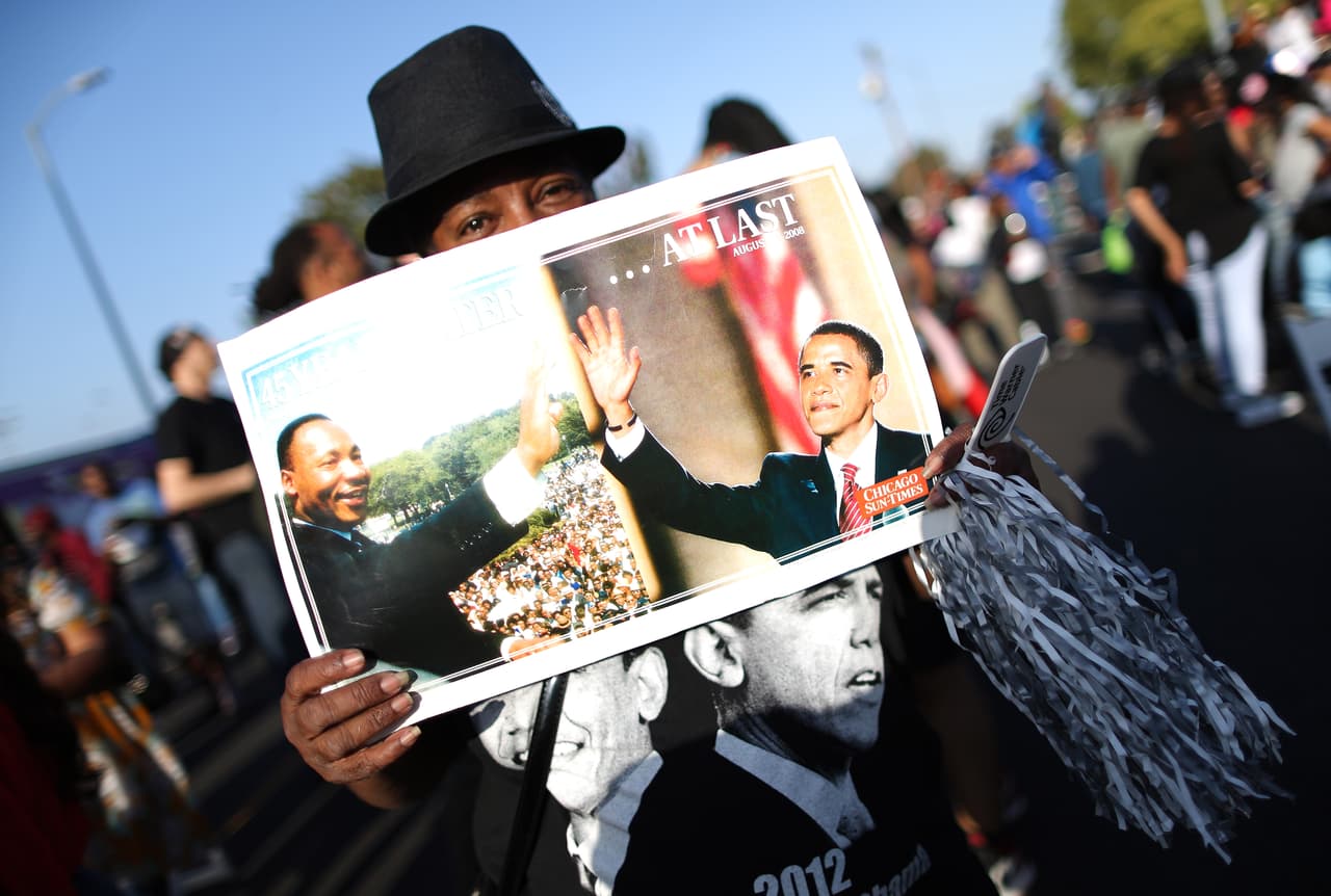 Un hombre muestra fotografías del ex presidente Obama durante el festival de música que fue celebrado junto con la inauguración de la autopista.