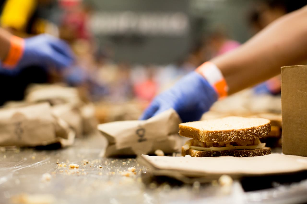 Este viernes preparaban kilos y kilos de arroz con habichuelas; sándwiches de jamón, queso y pollo; y pasta. Muchas personas se acercaron al Coliseo de Puerto Rico, en San Juan, donde se encuentra el centro de esta operación de producción de alimentos. La meta del día era alcanzar los 10,000 sándwiches.