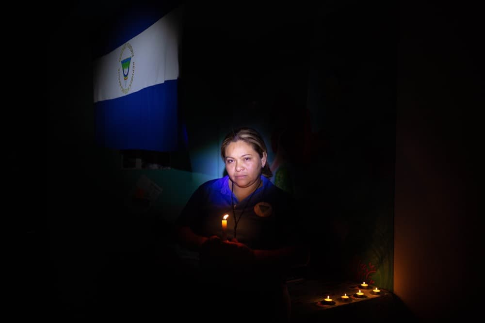 Erika Sánchez posa con una bandera de Nicaragua al revés en el fondo que, para ella, significa "un símbolo de protesta".