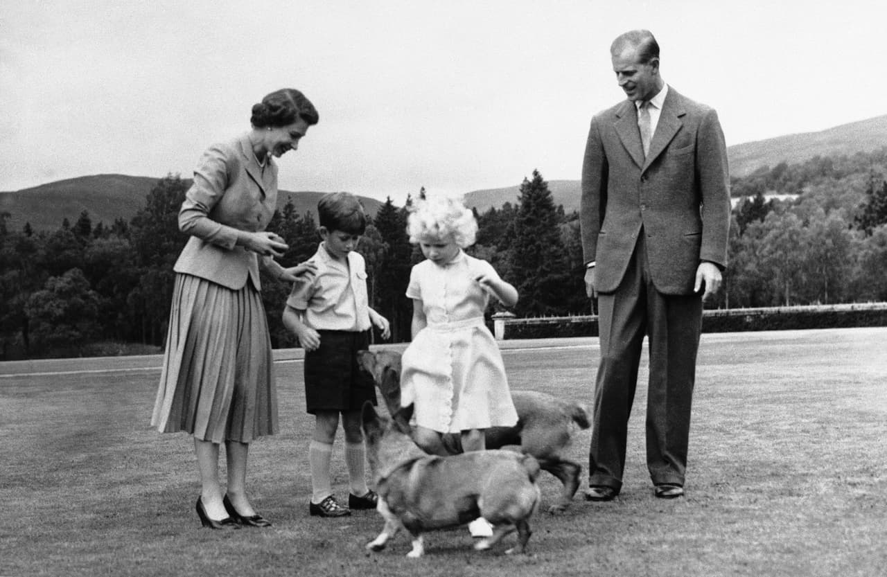 La reina Isabel II y su esposo, el príncipe Felipe, y sus hijos, los príncipes Carlos y Ana, juegan con dos de los corgis: "Sugar", propiedad de la monarca y "Candy", de su esposo. La fotografía es del 15 de agosto de 1955.