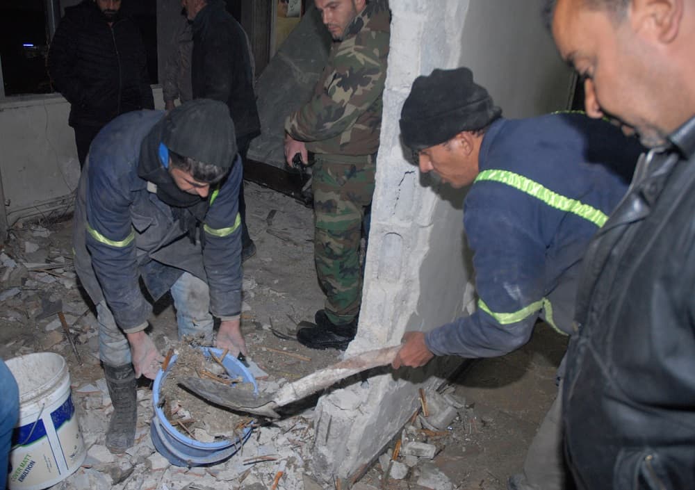 Trabajadores tratan de retirar los escombros tras la explosión en la comisaría.