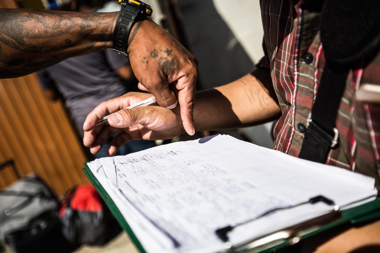 Un coordinador del albergue revisa la lista de pasajeros junto con el encargado de la línea privada de autobuses que los trasladará hasta Tapachula. Según los encargados de distintos refugios de migrantes, 
<b>en las últimas tres semanas las listas de quienes quieren regresar a sus países de origen son cada vez más largas.</b> Se apuntan de 20 a 50 personas, entre otras razones, porque 
<b><a href="https://www.univision.com/noticias/inmigracion/en-buses-o-en-vuelos-pagados-por-trump-la-angustia-lleva-a-los-centroamericanos-que-esperan-en-mexico-a-devolverse-a-sus-paises">la espera es demasiado larga</a></b>, ya sea para la primera fecha de corte con un juez de inmigración o para que les toque apenas ingresar con su número para ser interrogados por CBP.
<br>