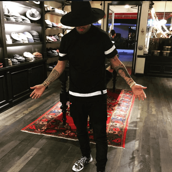 ¿Quién está debajo de ese sombrero? Es Nicky Jam, midiéndose uno de los sombreros que tanto le gustan.