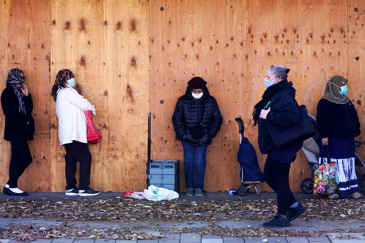 Una fila de personas espera que abra un centro de ayuda y despensa de alimentos en Chicago, Illinois, el 12 de noviembre. Las solicitudes de beneficios por desempleo subieron la semana pasada a 742,000, el primer incremento en cinco semanas y un indicio de que el nuevo pico de la pandemia sigue golpeando la economía.
<br>