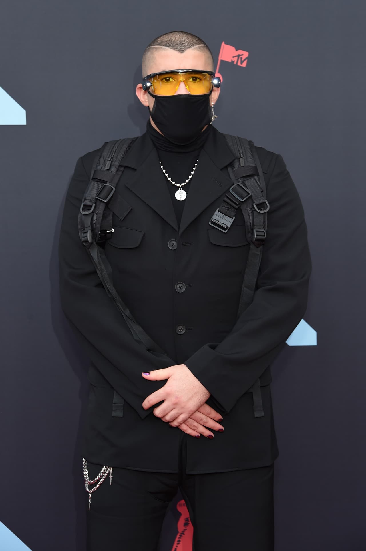 Tal parece que hay todo un discurso estético en los estrambóticos atuendos del cantante puertorriqueño. Para muestra esta imagen de finales de 2019 en donde luce un traje sofisticado con toques militares y la cara cubierta casi en su totalidad.