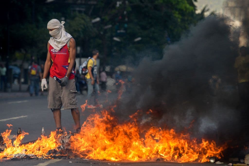 La imagen muestra momentos en los que la policía anti-disturbios y los manifestantes chocan en las calles de Caracas.