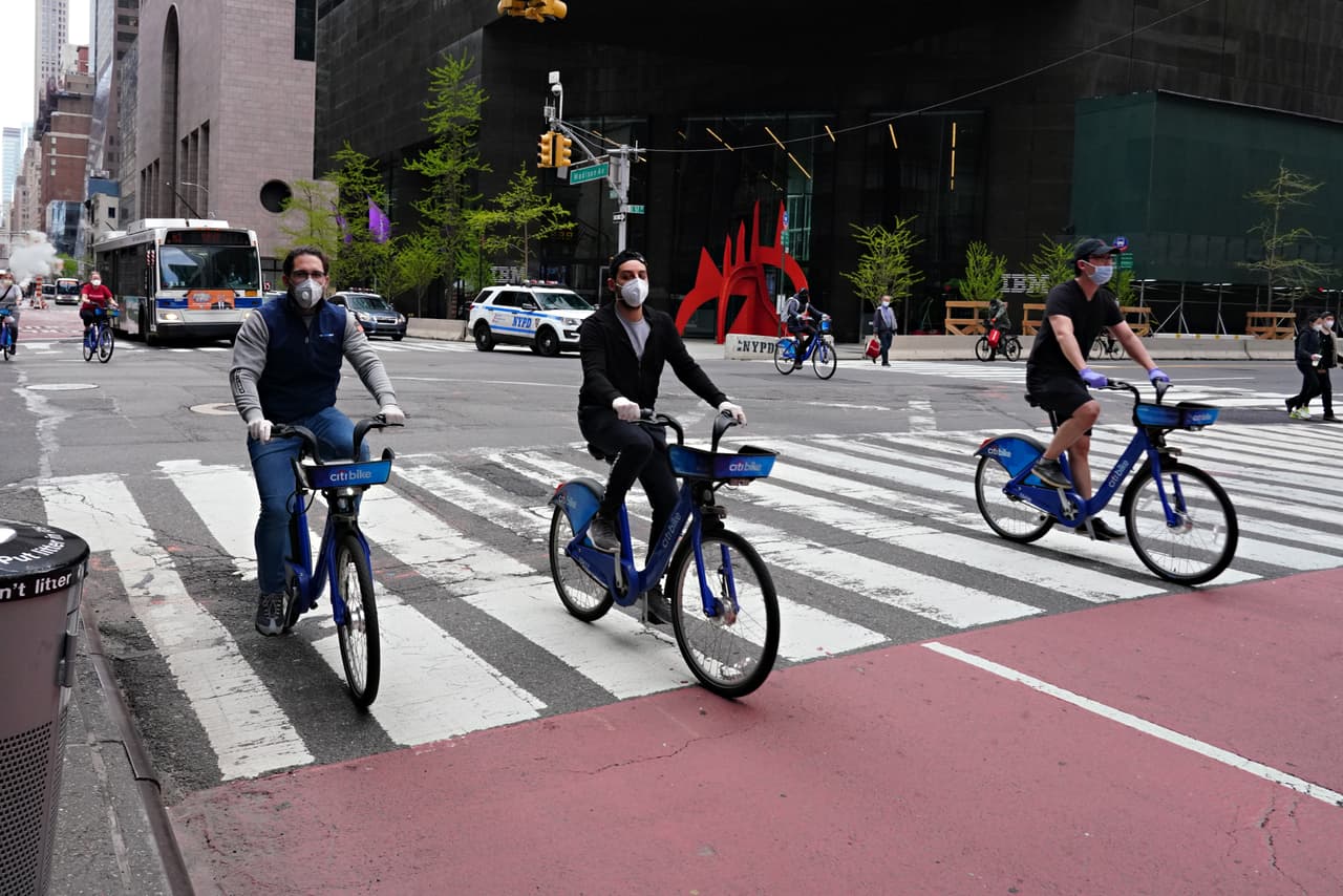 Ciclistas viajan por Manhattan usando máscaras protectoras. El ciclismo es una de las pocas actividades recreativas al aire libre en las que los neoyorquinos todavía pueden participar, aunque se aconseja que la gente ande sola para respetar las reglas de distanciamiento social.