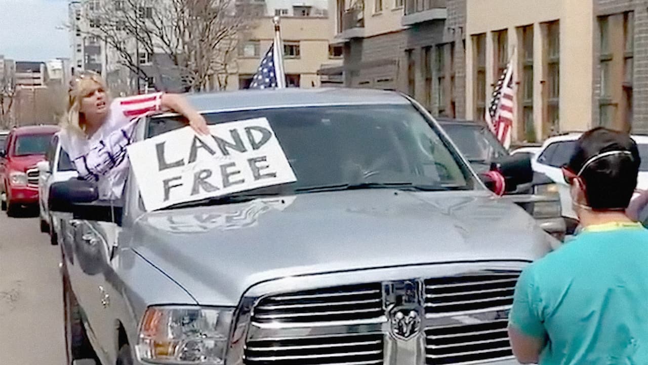 <b>“Tierra Libre”</b>, se lee en la pancarta que lleva una manifestante en una caravana en Denver, Colorado. Esta protesta fue interrumpida por un grupo de trabajadores de la salud que frenó el paso de los autos este 19 de abril.