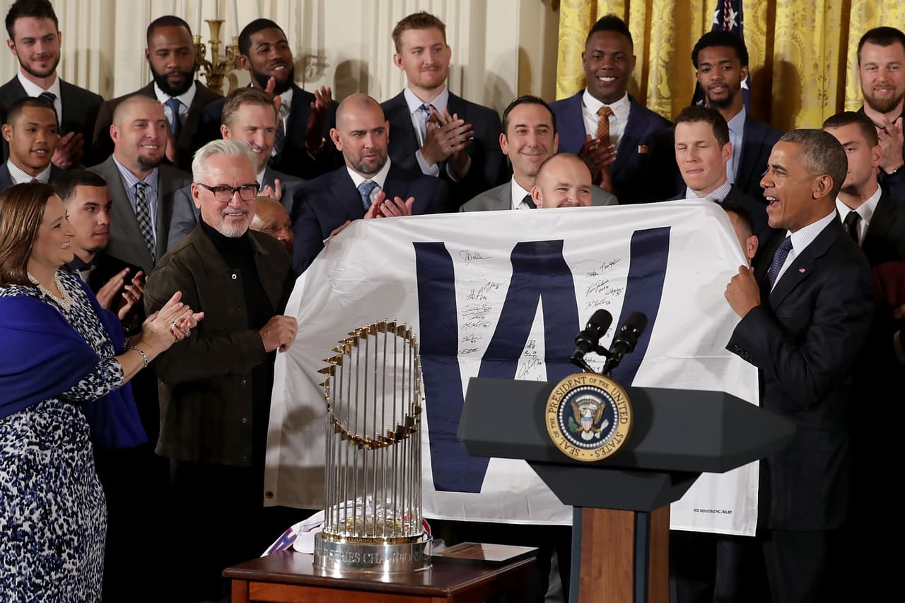 El presidente Barack Obama obtiene ayuda del campeón de la Serie Mundial de Béisbol de la Liga Americana, Joe Maddon, durante una celebración.