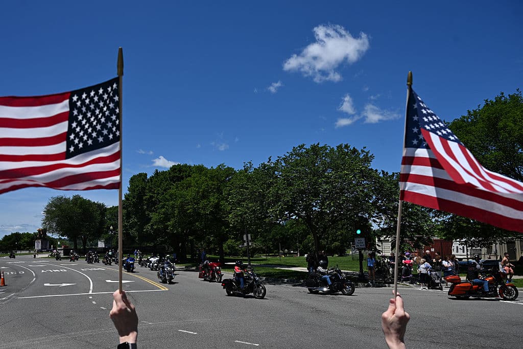 Las banderas ondeantes de Estados Unidos por toda la ruta del desfile-rodada muestran el patriotismo y agradecimiento en el corazón de los participantes y espectadores.