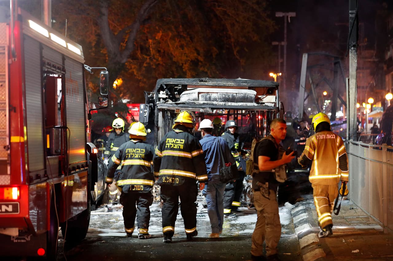 Bomberos israelíes inspeccionan un autobús quemado en el pueblo de Holon, cerca de Tel Aviv.