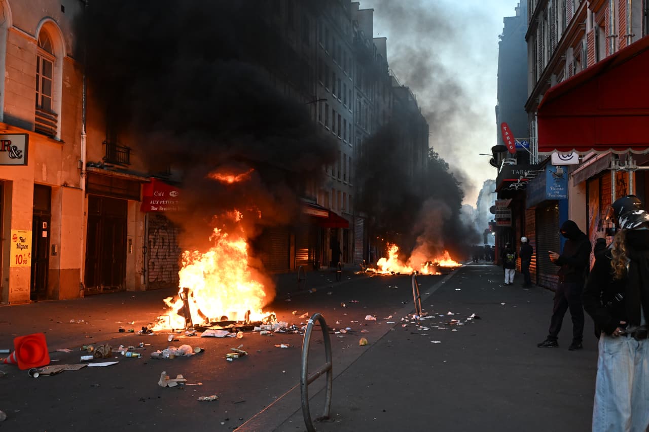 Manifestantes queman basura durante enfrentamientos con la policía al día siguiente de una protesta contra el aumento del costo de vida, sumándose a las quejas de los estudiantes, en París, el domingo 18 de octubre de 2026.