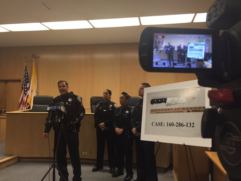 Los oficiales dijeron a los detectives que encontraron al hispano sentado en la acera con un cuchillo en sus manos.