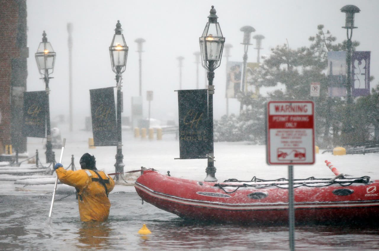 Un bombero camina por el agua helada que inundó el puerto de la ciudad de Boston, Massachusetts.