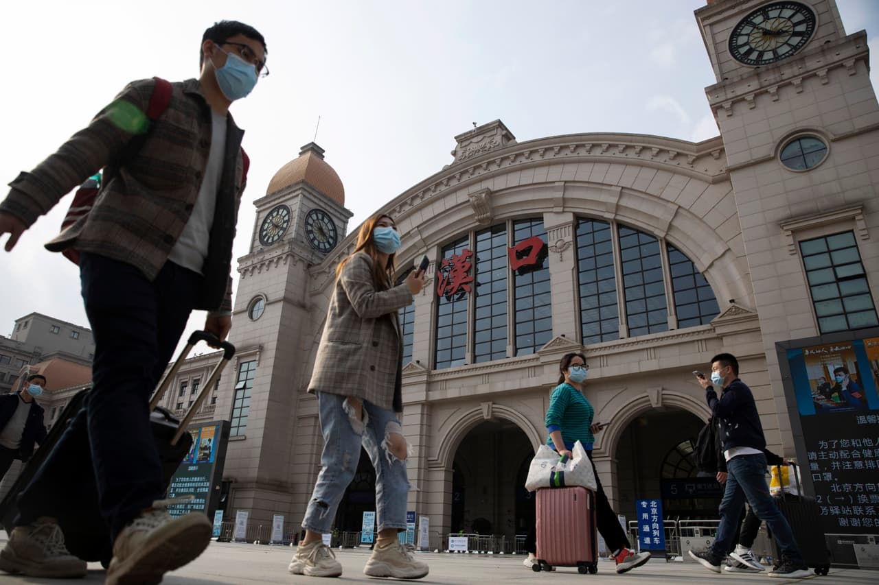 Pasajeros con equipaje en la ciudad de Wuhan, en la provincia de in central China's Hubei el 7 de abril de 2020. (AP Photo/Ng Han Guan)