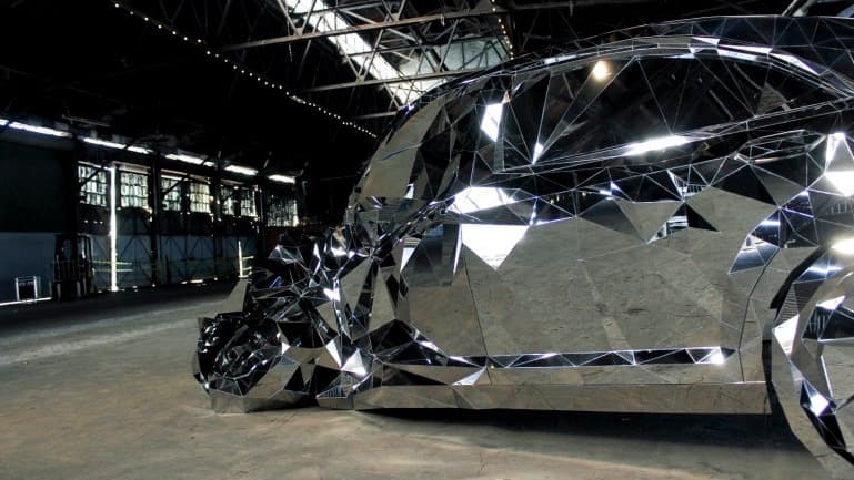 Utilizando los mapas digitales creados a partir del modelo, Griska creó una armazón de madera sobre la cual instaló miles de láminas de acero inoxidable, cada una distinta de la otra, cortadas con precisión milimétrica y pulidas a la perfección hasta convertirlas en espejos perfectos.