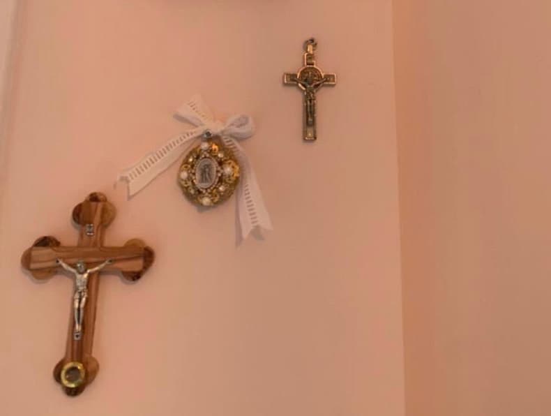 Uno de los rincones de 
<a href="https://www.univision.com/shows/primer-impacto/en-video-michelle-galvan-muestra-la-habitacion-rosa-de-su-bebe-video">la habitación</a> que más atesora Michelle es el pequeño espacio de la pared con regalos "sacros" que tiene mucho significado para la pareja.
<b> Entre los obsequios está una cruz de la suerte del abuelo de Fernando. </b>
<br>