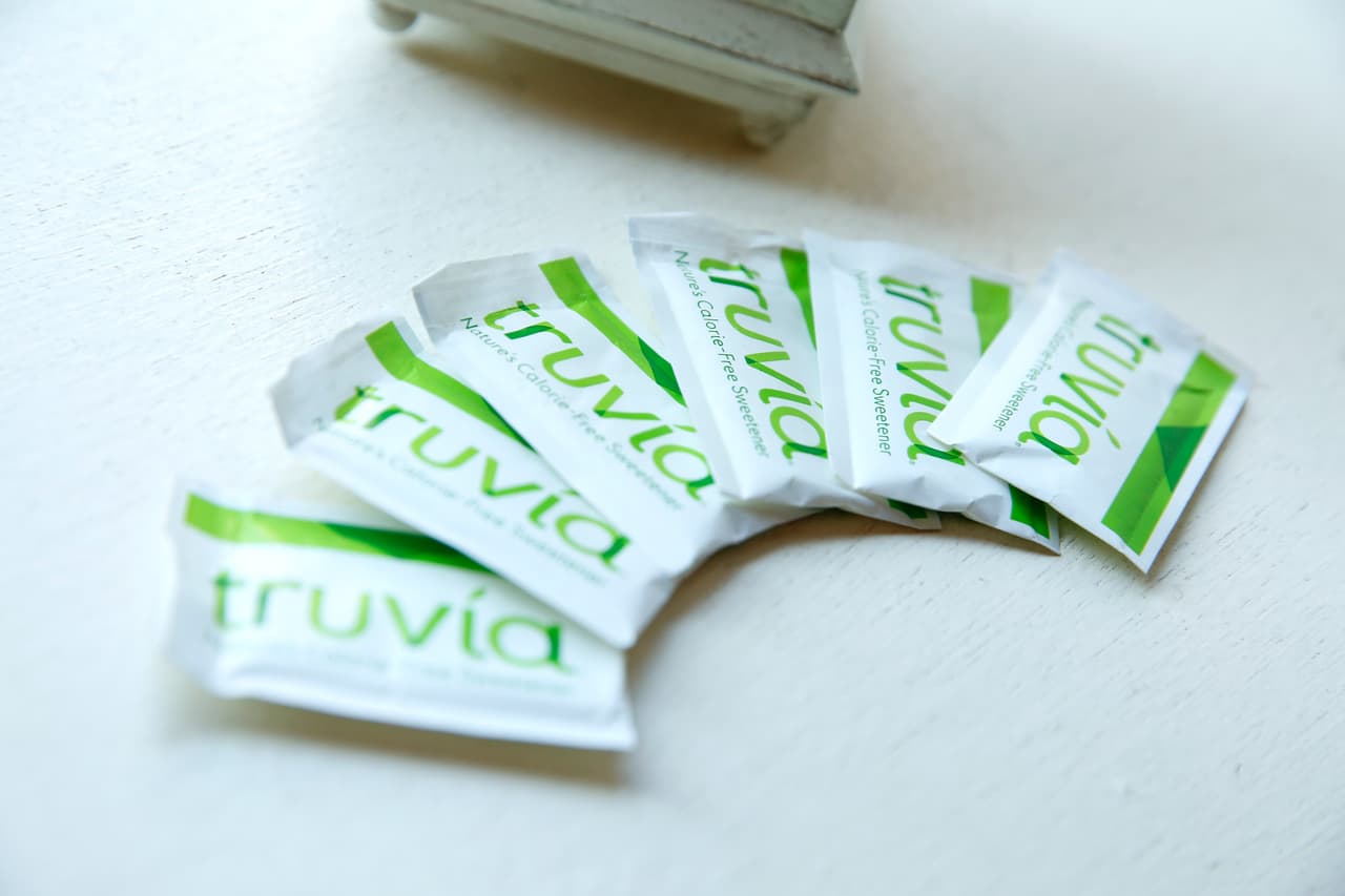 <b>Estevia / Truvia o PureVia (paquete verde)</b>
<br>Es el único edulcorante natural que no tiene calorías. Deriva de un extracto de la planta
<i>Stevia rebaudiana</i> y es entre 200 a 400 veces más dulce que el azúcar. Los guaraníes de Paraguay y Brasil han utilizado esta planta durante más de 1,500 años para endulzar tés y medicinas. Sin embargo, hoy en día
<b>su uso está limitado en muchos países</b>.
<br>
<br>Aporte calórico: hasta 1 caloría por paquete.