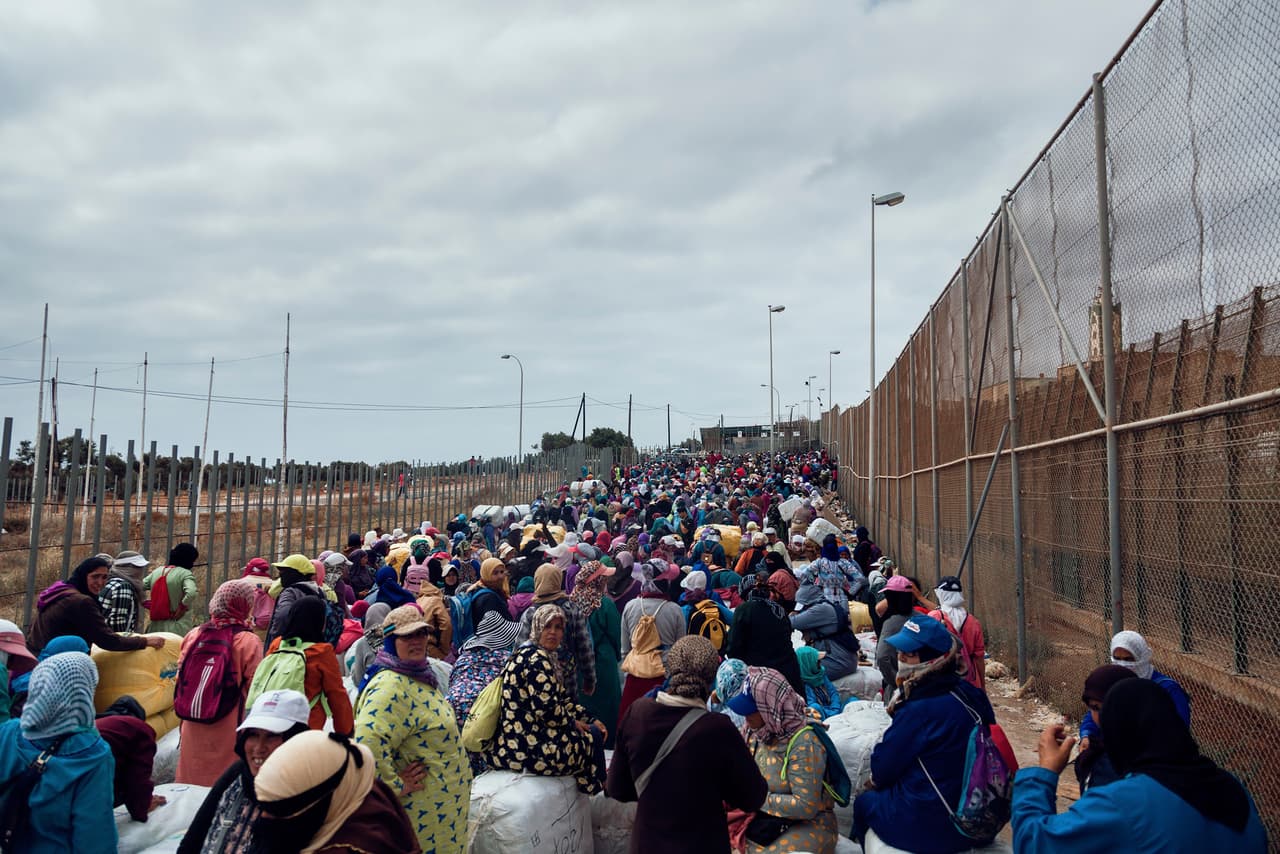 Los ‘porteadores’ son arrinconados por la Guardia Civil española que revisa los paquetes de mercancía golpeándolos con porras. Pasan horas expuestos al sol en altas temperaturas durante el verano antes de que se les permita continuar hacia Marruecos.