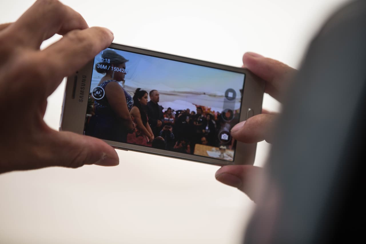 Un periodista filma la misa de los XV de Rubí con su celular.