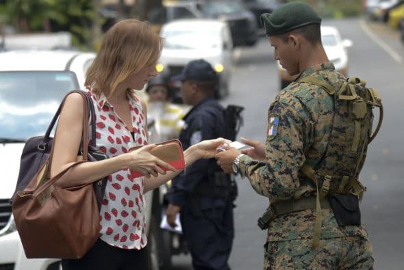 Un soldado del ejército de Panamá revisa los documentos de identidad de una ciudadana que vive en la zona aledaña del centro de convenciones donde estaba a punto de ser inaugurada la Cumbre.