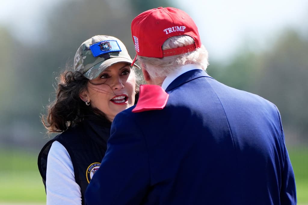 La gobernadora de Michigan, Gretchen Whitmer, saluda con un abrazo al presidente Donald Trump al aterrizar en Harrinon.
