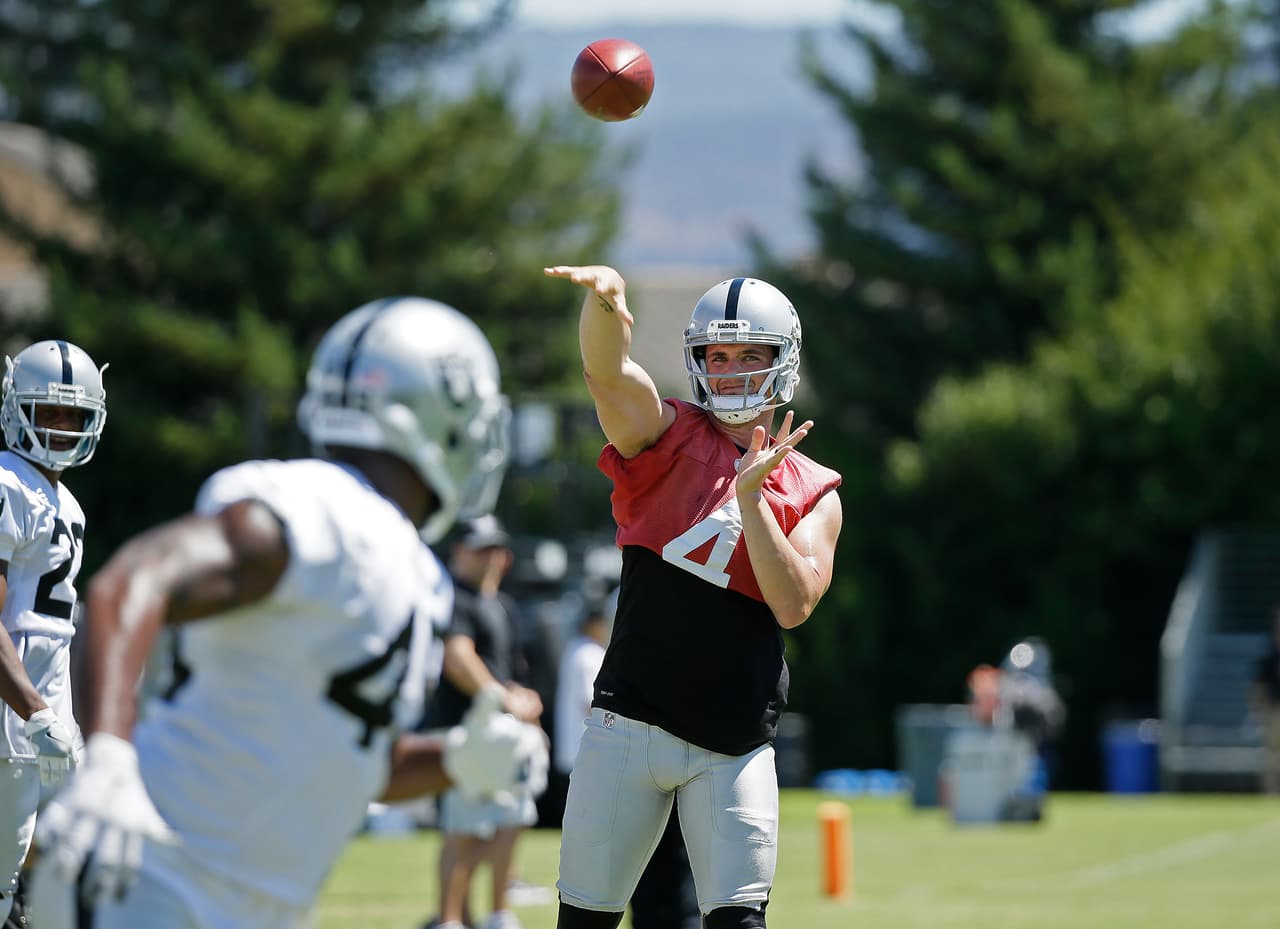 Oakland Raiders quarterback Derek Carr throws the ball to running back Jamize Olawale during practice at the NFL football team's training camp Saturday, July 30, 2016, in Napa, Calif. (AP Photo/Eric Risberg)