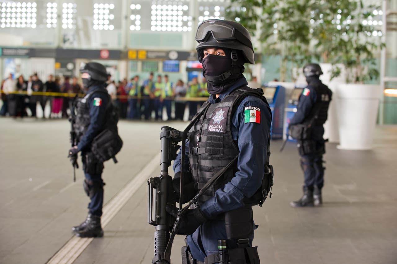 Policías federales resguardan la Terminal 2 del aeropuerto de la Ciudad de México después de la muerte de tres agentes en una disputa con otros oficiales del orden por un botín de drogas en 2012.