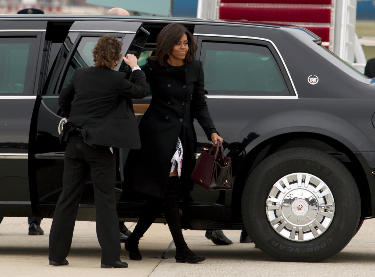 ¿Se cambió Michelle Obama antes de llegar a su histórico arribo a Cuba? En realidad no, por debajo de su 'coat' negro de botones, se puede ver cómo se cuela por el viento el vestido blanco que luciría unas horas después. Tan sólo se cambió las pesadas botas de invierno.