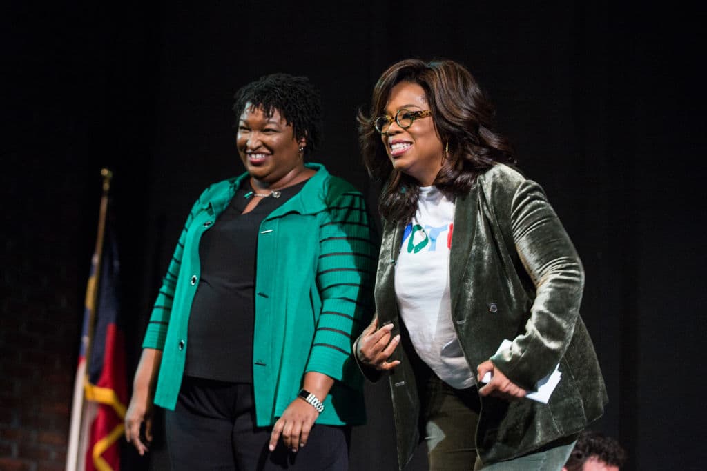 Oprah Winfrey and Georgia Democratic Gubernatorial candidate Stacey Abrams greet the audience during a town hall style event at the Cobb Civic Center on November 1, 2018 in Marietta, Georgia.