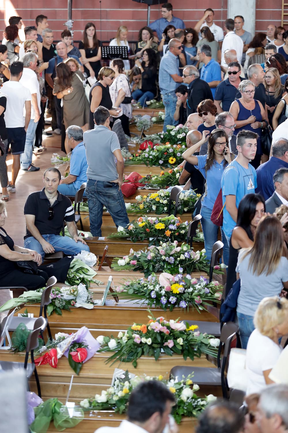 35 ataúdes fueron colocados en el suelo del gimnasio donde se celebraron los funerales